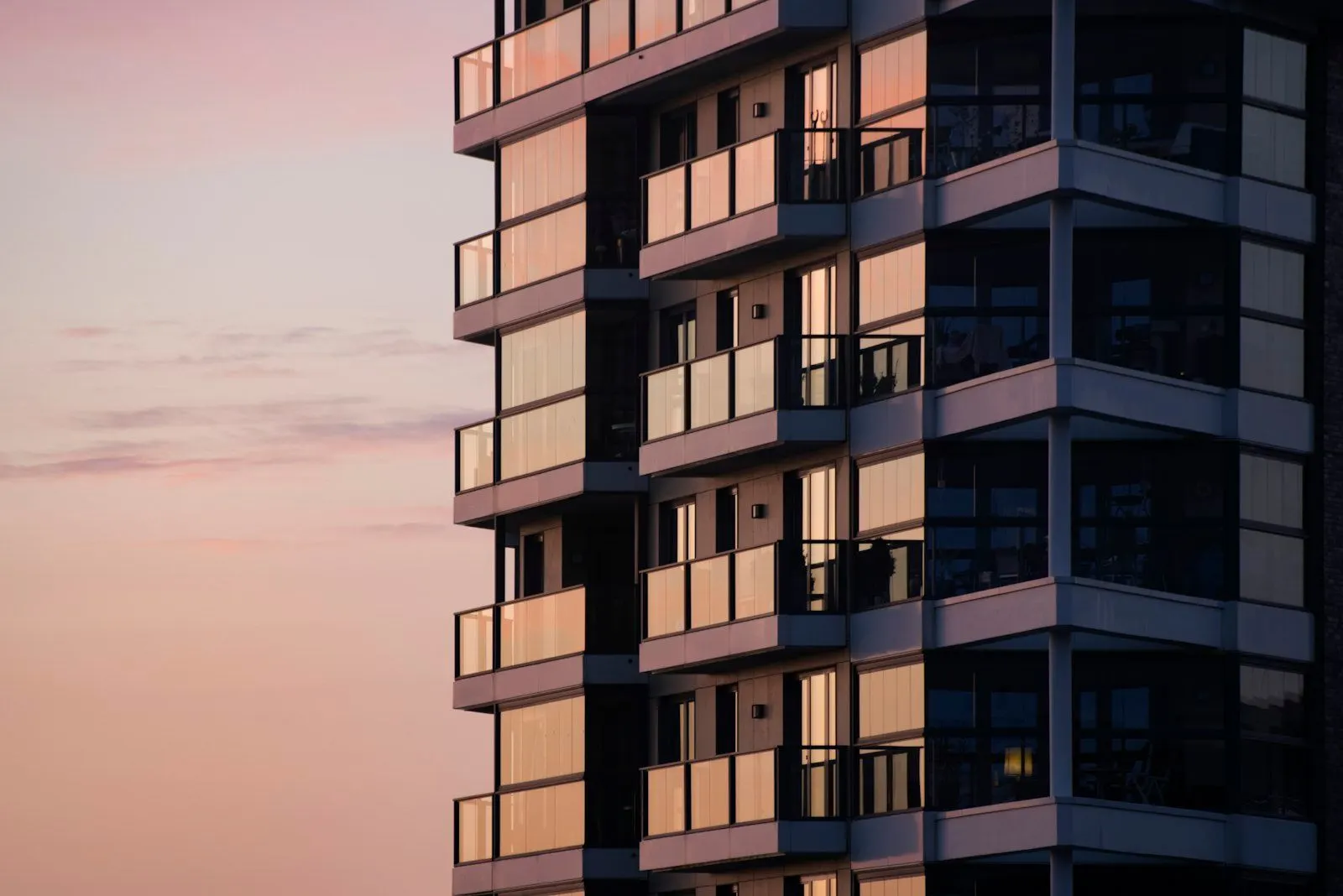 夕暮れ時のガラスバルコニーのあるモダンなマンション