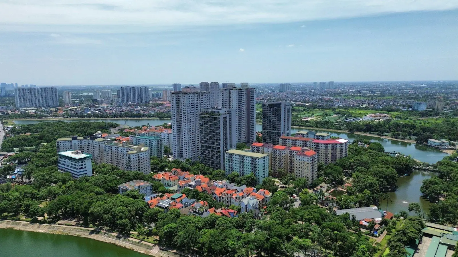 Khu dân cư ven đô nhìn từ trên cao với chung cư, nhà phố và hồ nước